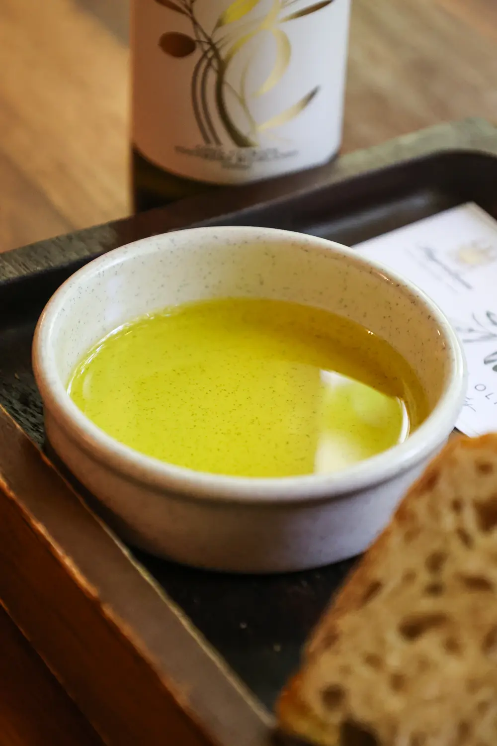 Close-up of extra virgin olive oil in a bowl with bread, emphasizing its natural use as a remedy to relieve constipation by aiding digestion and softening stools.