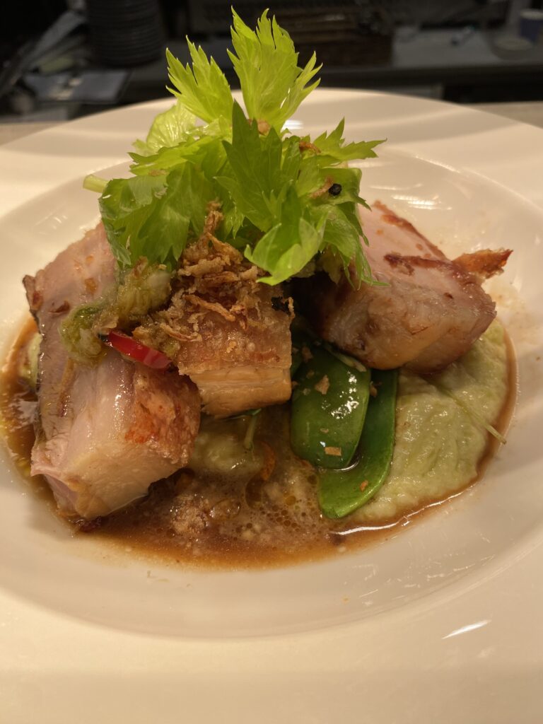 Pan-fried pork served with vegetables and sauce, showing how extra virgin olive oil can be safely used for high-heat stir-fry dishes while retaining flavor and health benefits